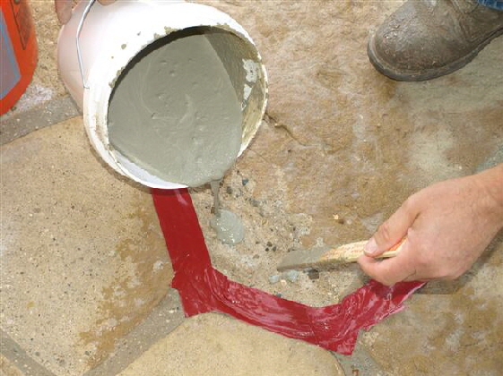 Applying cement veneer over treated surface.